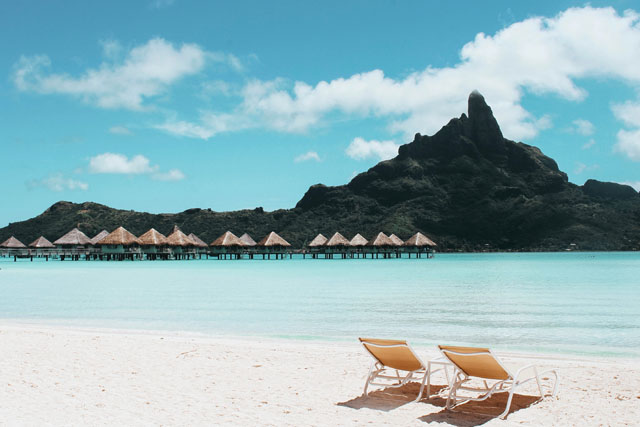 Beach With Cottages And Large Mountain